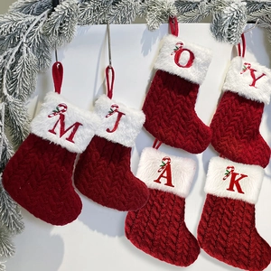 Red cable knit Christmas stockings with white faux fur cuffs and candy cane style letters