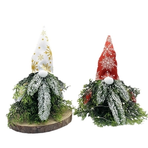 Christmas forest gnomes with pine needle beards and snowflake hats on wood bases