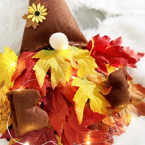 Gnome d'automne avec chapeau de tournesol, feuilles d'érable et lumières LED chaudes
