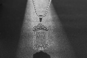 Macro detail of retro steel abacus pendant with traditional lion and wealth carving
