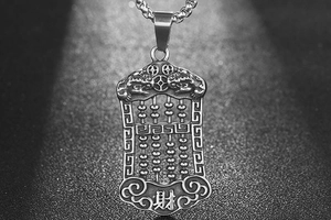 Macro detail of retro steel abacus pendant with Pixiu carving and wealth symbol