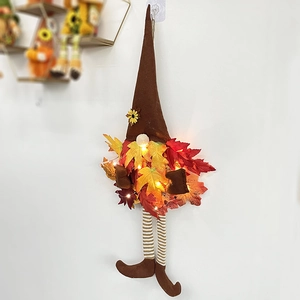 Détail d'un gnome suspendu lumineux avec feuilles d'érable et tournesols pour la récolte