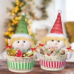 Close-up of festive Christmas elf dolls holding woven baskets with gift boxes