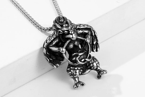 Detailed close-up of a vintage titanium steel Garuda pendant with intricate wing textures