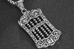 Macro shot of titanium steel abacus pendant with Pixiu carving and fortune symbol