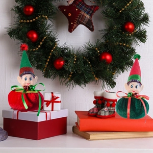 Detailed view of red and green plush Christmas elf ornaments with bells and velvet caps