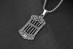 Macro shot of titanium steel abacus pendant with traditional dragon carving detail