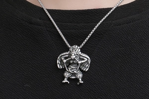 Macro detail of retro silver Garuda pendant with intricate carvings on square pearl chain