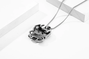 Detailed view of a vintage silver crab totem pendant on a stainless steel box chain