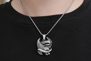 Close-up of vintage stainless steel eagle pendant with intricate engraved textures