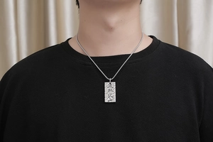 Dettaglio della collana con piastrina militare e incisione kanji L'arte della guerra su acciaio
