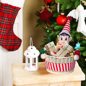 Weihnachtswichtel-Süßigkeitenkorb mit gestreifter Puppe auf festlichem Tisch