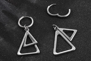 Détail des boucles d'oreilles en acier argenté avec pendentifs géométriques à double triangle