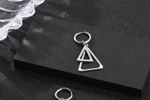 Détails des boucles d'oreilles triangles en acier inoxydable sur présentoir noir