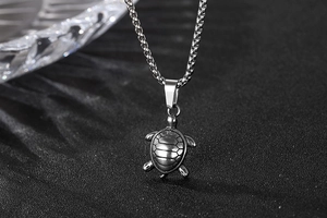 Macro detail of vintage silver stainless steel turtle pendant with textured shell details