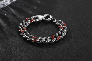 Gros plan d'un bracelet gourmette en acier titane argenté avec détails en émail rouge