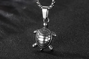 Macro shot of silver stainless steel sea turtle pendant with detailed shell texture