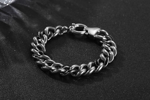 Gros plan d'un bracelet gourmette en acier inoxydable argenté avec fermoir à ressort rond