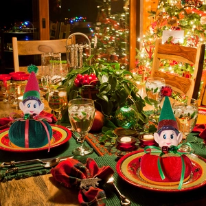 Detail of plush Christmas elf ornaments with velvet ball bases on a festive table