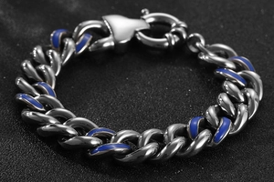 Vue macro de bracelet gourmette argenté avec incrustation d'émail bleu et fermoir