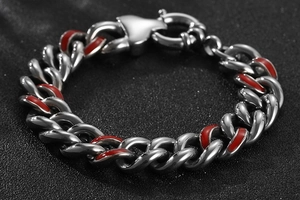 Détail macro du bracelet gourmette pour homme en acier titane avec émail rouge