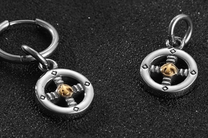 Macro detail of stainless steel eagle pendant earrings with vintage metallic texture