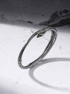 Vue détaillée des écailles du bracelet serpent et des yeux en gemme rouge sur pierre