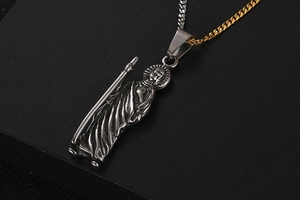 Detailed macro view of vintage titanium steel religious saint relief pendant on cuban chain