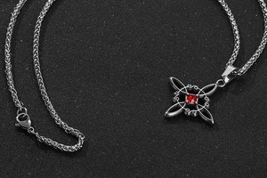 Gros plan d'un pendentif nœud celtique en acier titane avec un zircon rouge poli