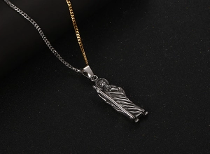 Close-up of vintage religious pendant on a unique gold and silver two-tone curb chain