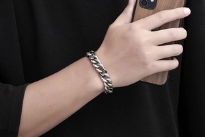 Détail du bracelet gourmette en argent vintage au poignet d'un homme élégant