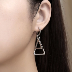Boucles d'oreilles triangulaires en acier inoxydable portées par un mannequin en gros plan
