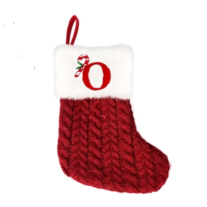 Macro shot of red cable knit Christmas stocking with plush cuff and embroidered letter O