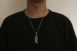 Close-up of Saint Jude religious pendant on a dual-tone gold and silver curb chain