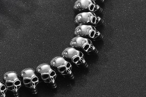 Makroaufnahme eines Totenkopf-Armbands im Punk-Stil aus poliertem silbernem Edelstahl