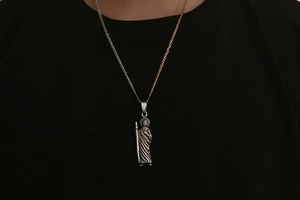 Detail of vintage silver icon pendant on two-tone gold and silver chain shown on model