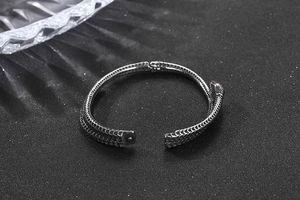 Détail du bracelet serpent en métal argenté avec écailles et cristaux rouges