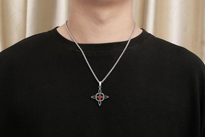 Pendentif étoile en acier titane avec gemme rouge porté sur un t-shirt noir