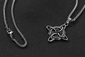 Détail macro du pendentif nœud celtique argenté avec chaîne épi sur fond texturé