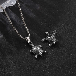 Vintage silver stainless steel sea turtle pendant necklace set on a dark textured background