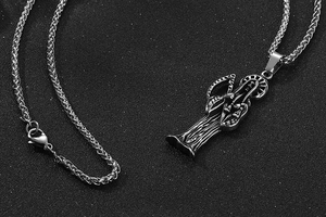 Gros plan détaillé du pendentif faucheuse en acier inoxydable avec faux sur une chaîne