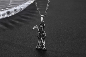 Detailed macro view of retro silver Grim Reaper pendant with scythe and twist chain