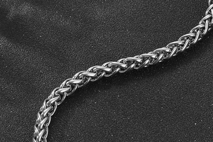 Macro shot of silver wheat link chain bracelet with polished stainless steel texture