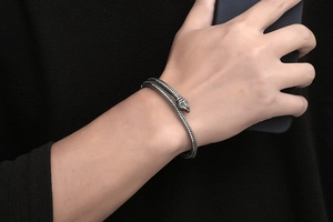 Gros plan détaillé du bracelet serpent avec écailles argentées et yeux rouge rubis