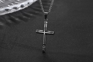 Macro view of a retro stainless steel cross pendant with detailed dot texture and chain