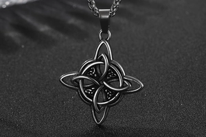 Détail macro du pendentif nœud de sorcière en acier inoxydable noir sur fond de sable