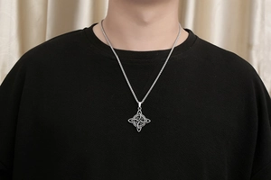 Gros plan d'un collier pendentif nœud celtique en argent vintage porté par un mannequin