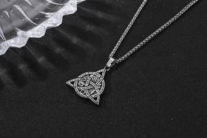 Macro view of retro silver triquetra pendant with occult symbols and wheat chain