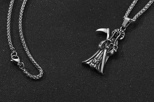 Macro detail of gothic Grim Reaper pendant with intricate scythe and wheat chain link