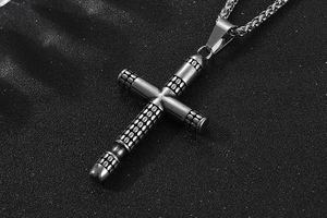 Detailed macro view of vintage cross pendant with dotted texture and industrial punk chain